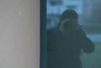 Rear view of man looking through window