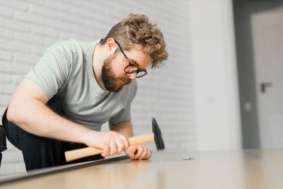 Side view of young man exercising in gym