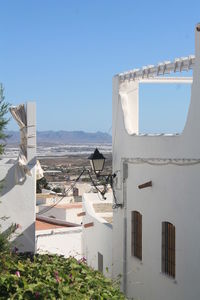 Buildings in city against clear blue sky