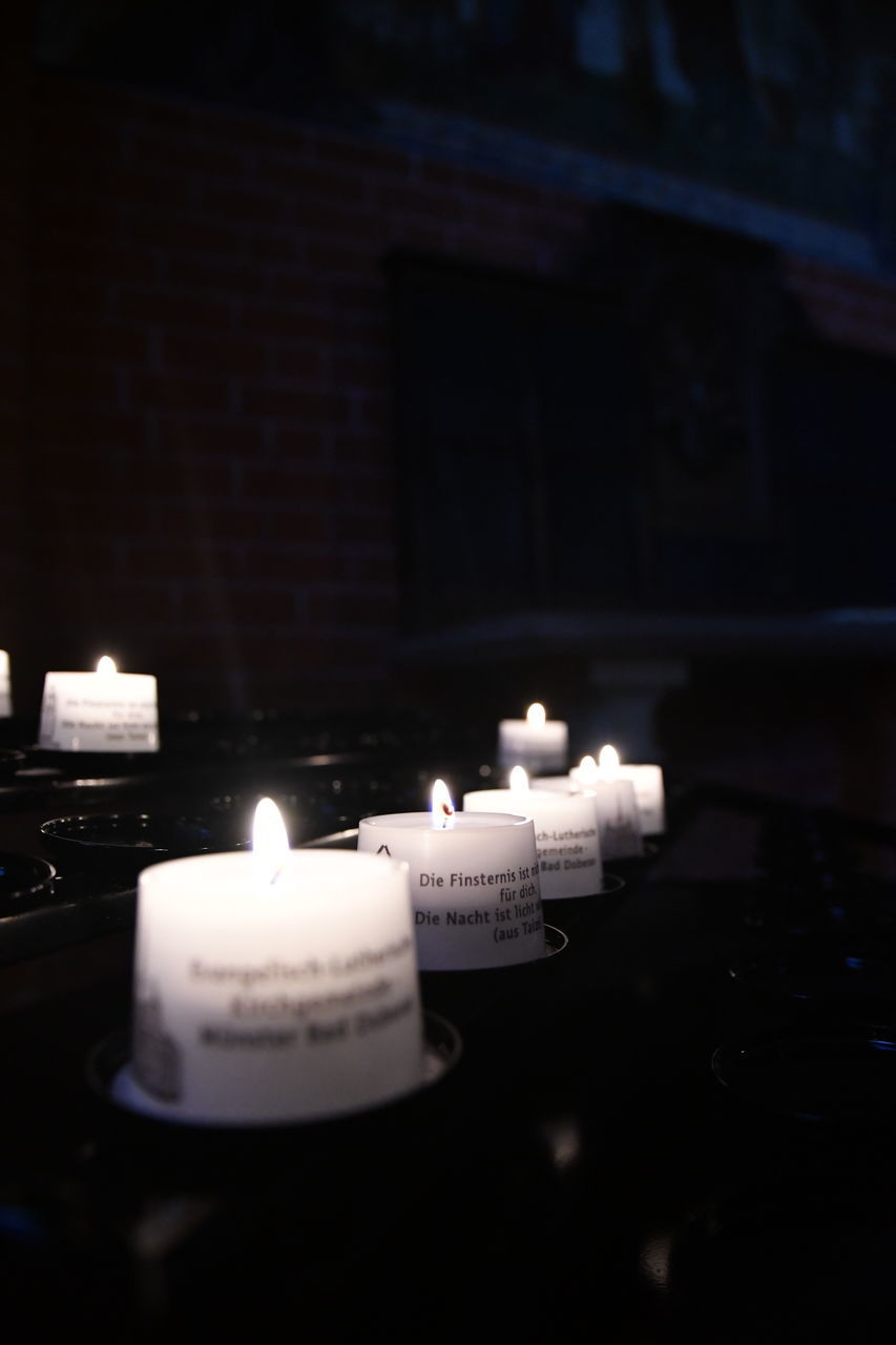 CLOSE-UP OF LIT CANDLES IN TEMPLE