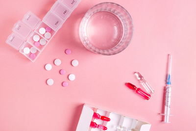 Directly above shot of beauty products against pink background