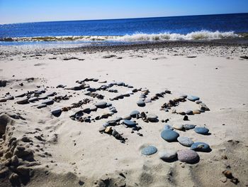 Surface level of stones on beach against sky