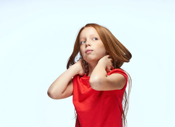 Portrait of young woman standing against white background