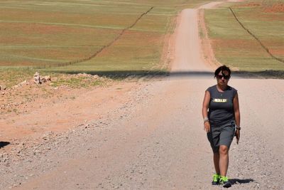 Full length of young woman on road