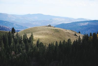 Scenic view of house on top of mountain against sky