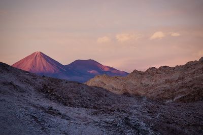 Scenic view of arid landscape against sky during sunset