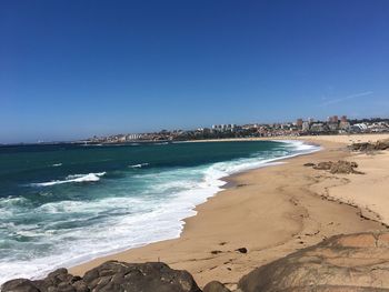 Scenic view of beach against clear blue sky