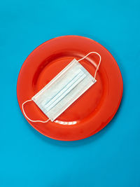 High angle view of red plate against blue background