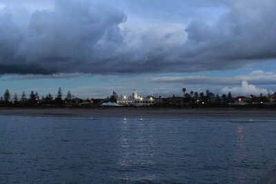 Scenic view of sea and city against cloudy sky