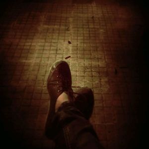 Low section of man standing on tiled floor