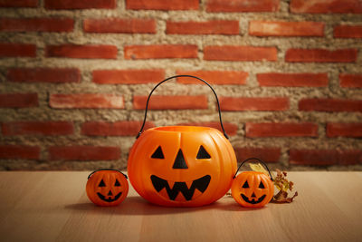 Close-up of pumpkin on table against brick wall during halloween