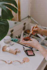 Cropped hand of woman holding make up brush