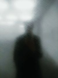 Reflection of man on frosted glass