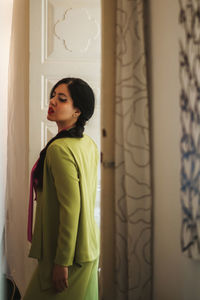 Portrait of young woman standing at home