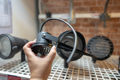 Cropped hand of person holding equipment at store