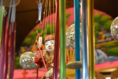 Low angle view of male puppet hanging amidst colorful decorations