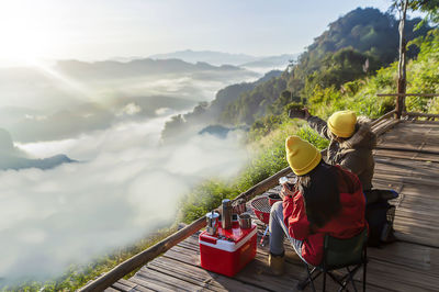 Rear view of people on mountain against sky