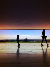 Silhouette of woman against clear sky at sunset