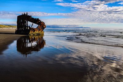 Lifeguard hut on beach against sky