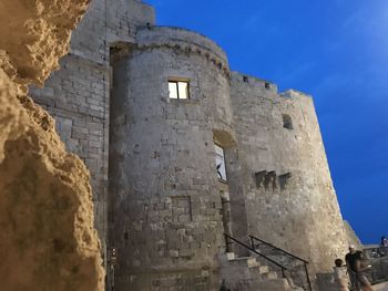 Low angle view of old building against blue sky