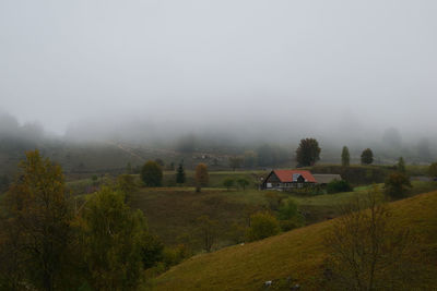 Scenic view of field against sky during foggy weather