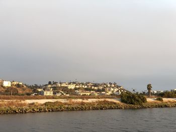 Scenic view of sea by buildings against sky