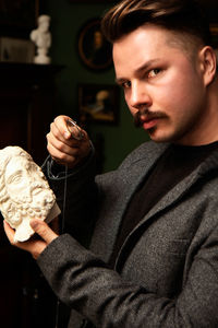 Portrait of young man holding camera