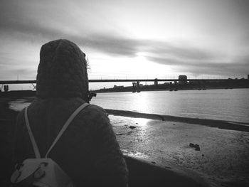 Rear view of man looking at sea against sky