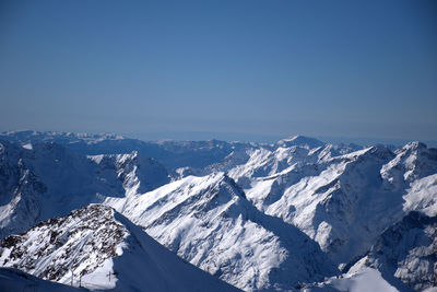 Scenic view of snowcapped mountains against clear blue sky