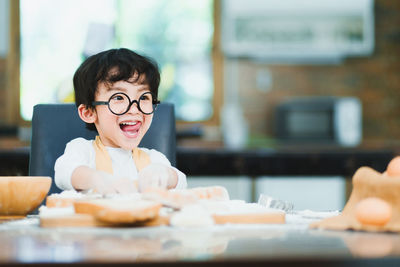 Portrait of boy with ice cream on table