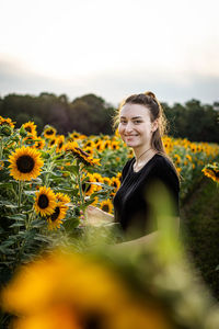 Portrait of smiling woman on sunflower field
