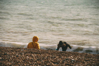 Friends sitting on shore at beach