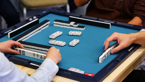 A mahjong table with an active game and the hands of the participants in the game. 