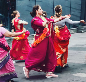 Group of people dancing on street in city
