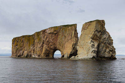 Rock formation in sea against sky