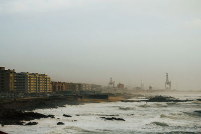 Scenic view of sea and buildings against clear sky