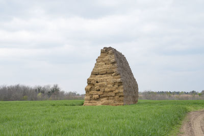 Stone wall on field against sky