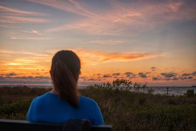 Rear view of woman looking at sunset