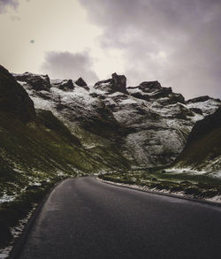 Road by mountain against sky