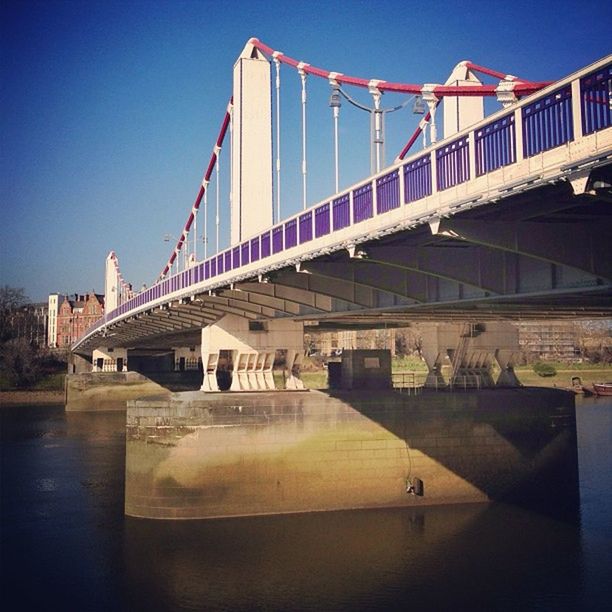 architecture, built structure, clear sky, bridge - man made structure, water, blue, connection, river, building exterior, engineering, railing, waterfront, sky, city, sunlight, day, outdoors, no people, copy space, travel destinations