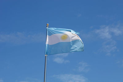 Low angle view of flag against blue sky