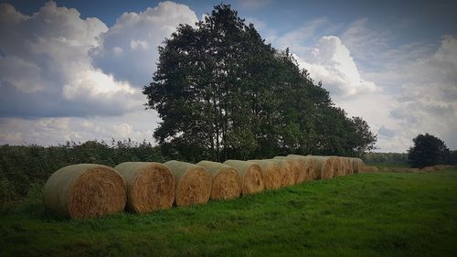 Hay bales on field against sky