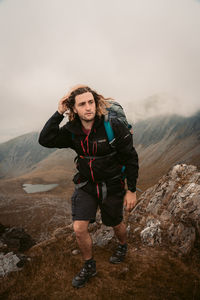 Portrait of teenage  standing on mountain against sky