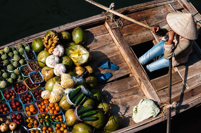 High angle view of person selling fruits and vegetables on boat in river