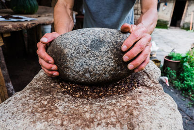 Midsection of man holding rock