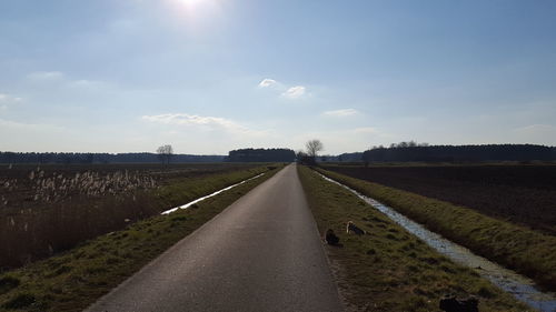 Surface level of empty road against cloudy sky