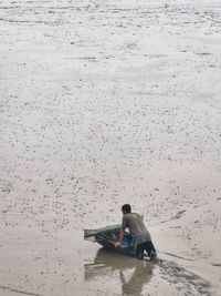 Rear view of a man sitting on beach