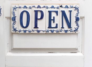 Close-up of open sign on white door