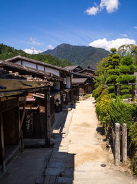 Walkway amidst buildings against sky