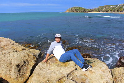 Portrait of man on rock at sea shore